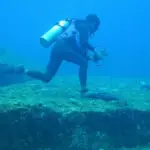 Plongeur au-dessus de blocs rocheux en terrasses sous l'eau
