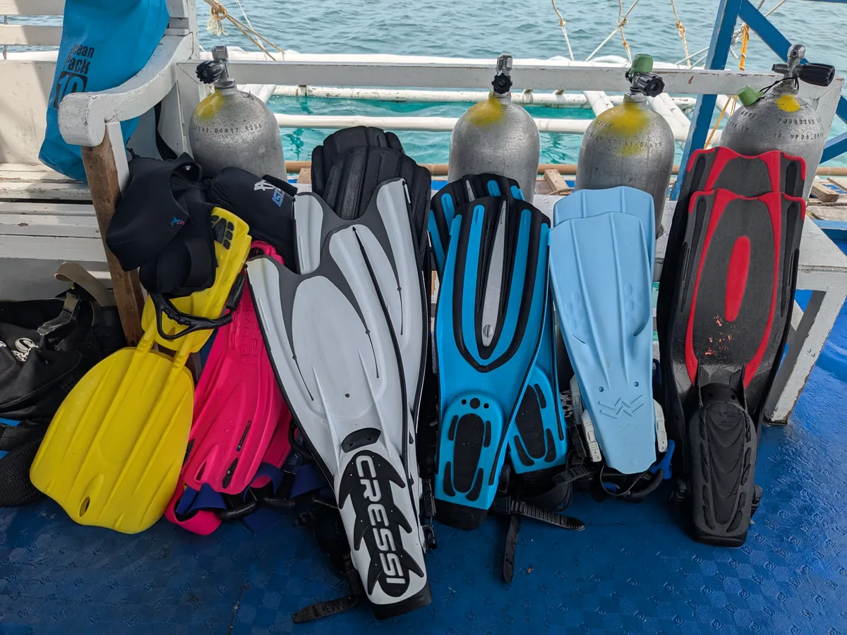 Rangée de palmes de plongée de différentes couleurs sur un bateau de plongée