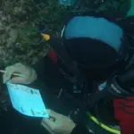 Plongeur écrivant sur une ardoise de plongée à Tavolara, en Sardaigne