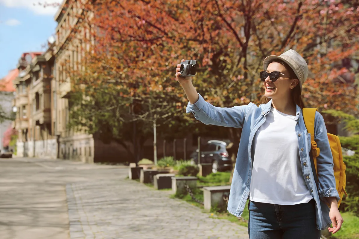 Touriste photographiant une vieille ville sous le soleil d'automne